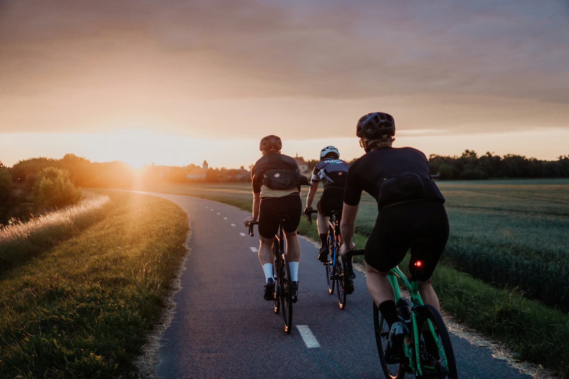 Rennradfahrer bei Sonnenuntergang auf einer Landstraße im Burgenland